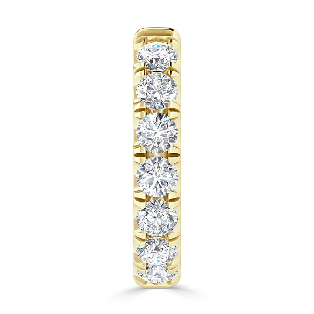 Vertical gold ring set with seven round diamonds in a single row, viewed from the front.