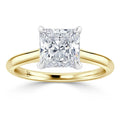 A gold ring with a square princess-cut diamond set in a four-prong solitaire setting.