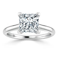 A solitaire ring with a princess-cut diamond set on a simple white gold band, viewed from the front.