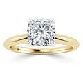 Gold band ring with a large, cushion-cut diamond solitaire set in a four-prong white gold or platinum setting.