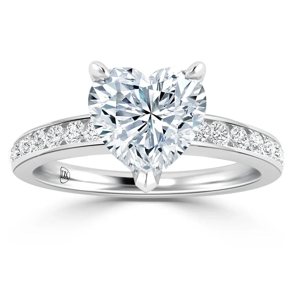 A heart-shaped diamond ring with smaller diamonds set along a silver band, displayed on a white background.