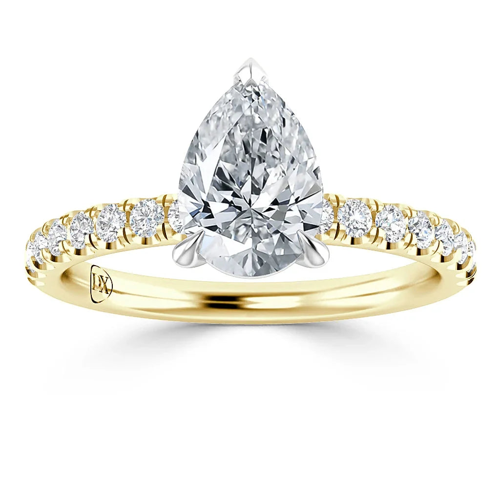 A gold ring with a large pear-shaped diamond center and small round diamonds on the band.