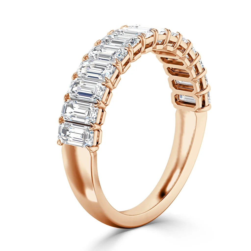 Rose gold ring with a row of rectangular emerald-cut diamonds set along the top half of the band.