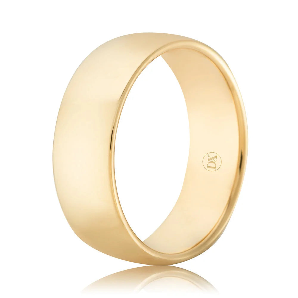 A plain, polished yellow gold ring with a smooth, rounded surface and a small engraved logo on the inside.
