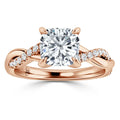 Rose gold ring with a large cushion-cut diamond center and a twisted band accented with small diamonds.