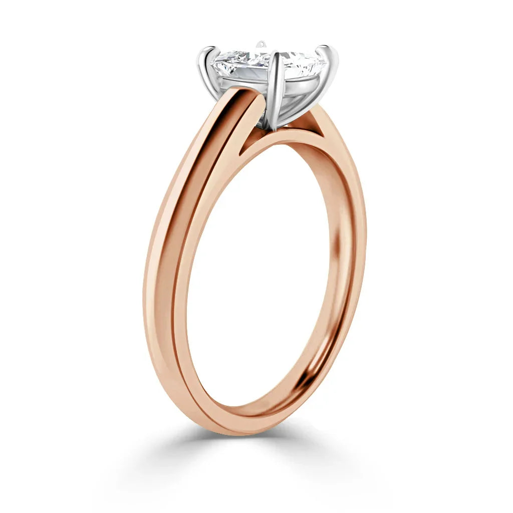 Rose gold ring with a round diamond solitaire set in a white gold prong setting, viewed from the side.