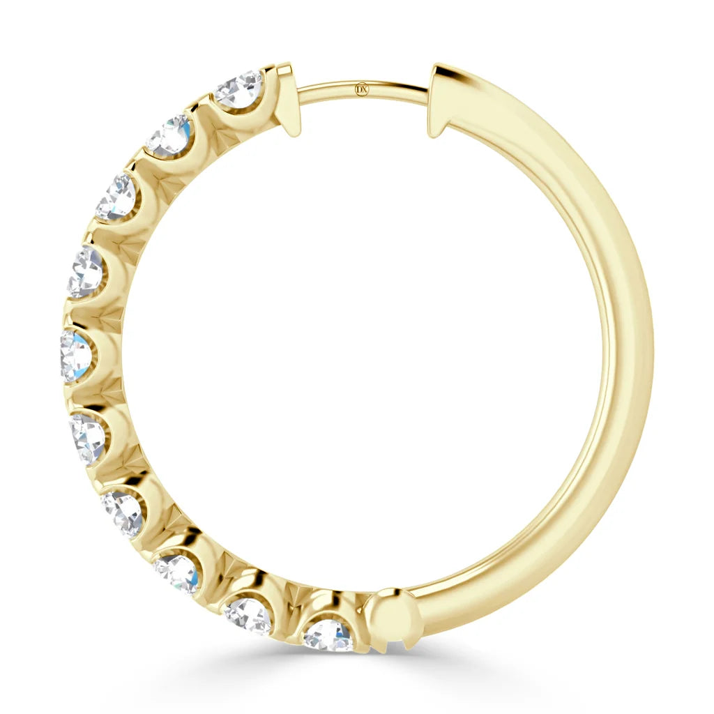 A gold hoop earring with clear round gemstones set along half of its outer curve, shown on a white background.