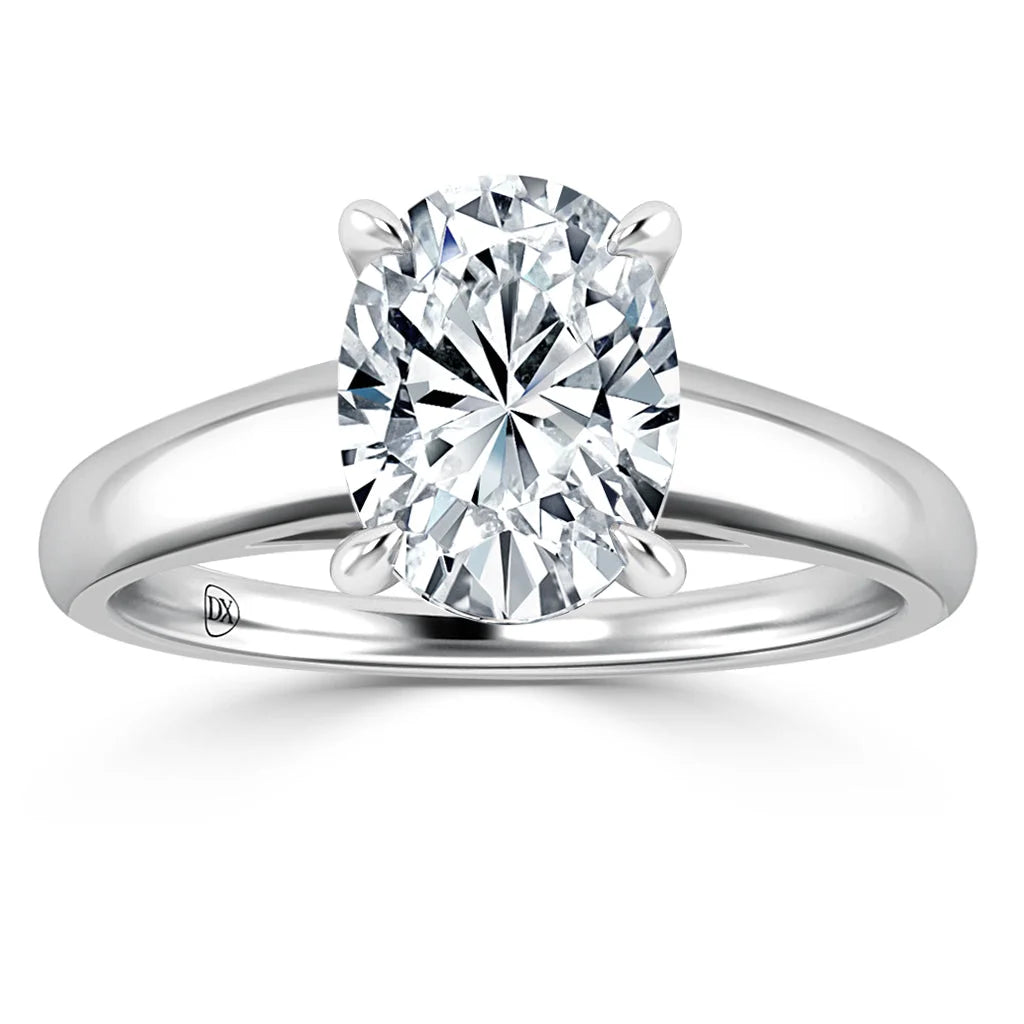 Oval-cut diamond solitaire ring with four prongs on a sleek, polished white metal band, shown on a white background.