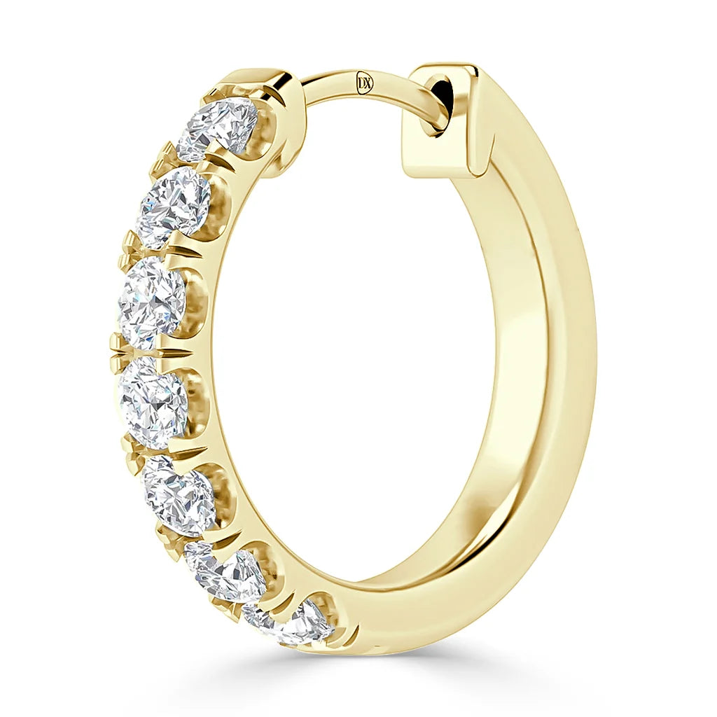 Gold hoop earring with several round, white diamonds set along the front half of the hoop.