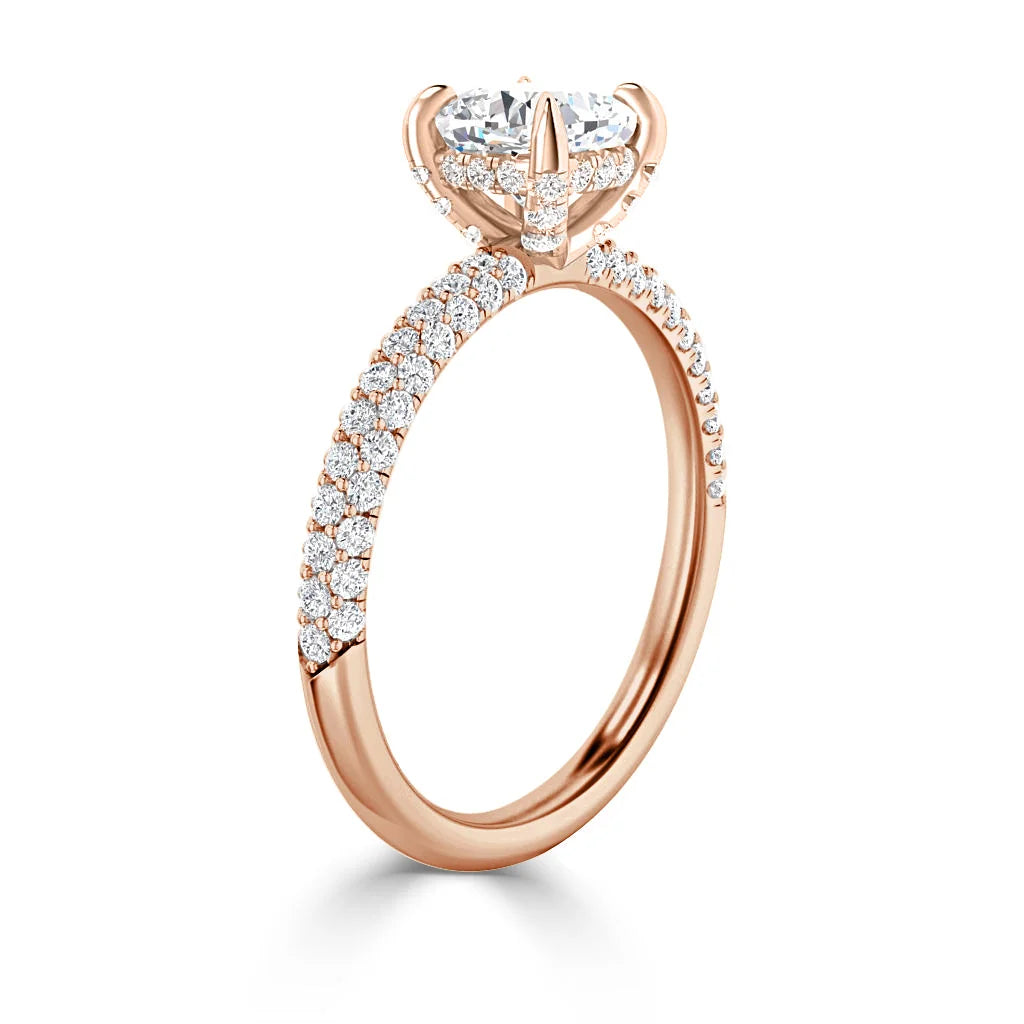 A rose gold engagement ring with a large round diamond and pavé diamonds on the band.