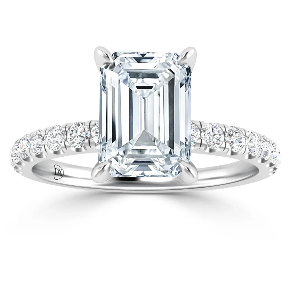Emerald-cut diamond ring with pavé diamond band on white gold setting, shown against a white background.