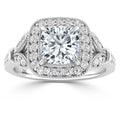 White gold ring with cushion-cut center diamond, surrounded by a halo and side diamonds in a vintage-inspired setting.