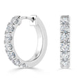 Silver hoop earrings with a row of sparkling round-cut diamonds set along the front edge.