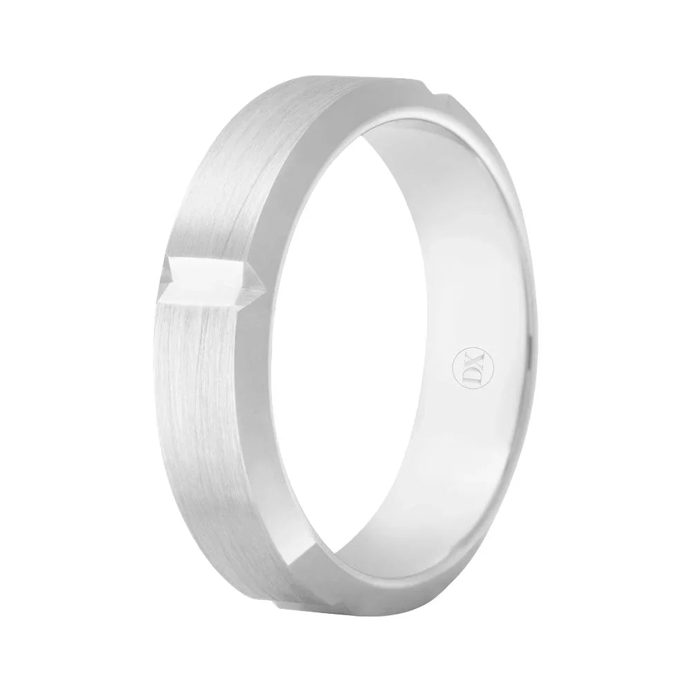 A silver ring with a matte finish, flat edges, and a small raised geometric detail on one side.