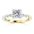 Gold ring with a large square diamond center and marquise side stones set along the band in a leaf pattern.