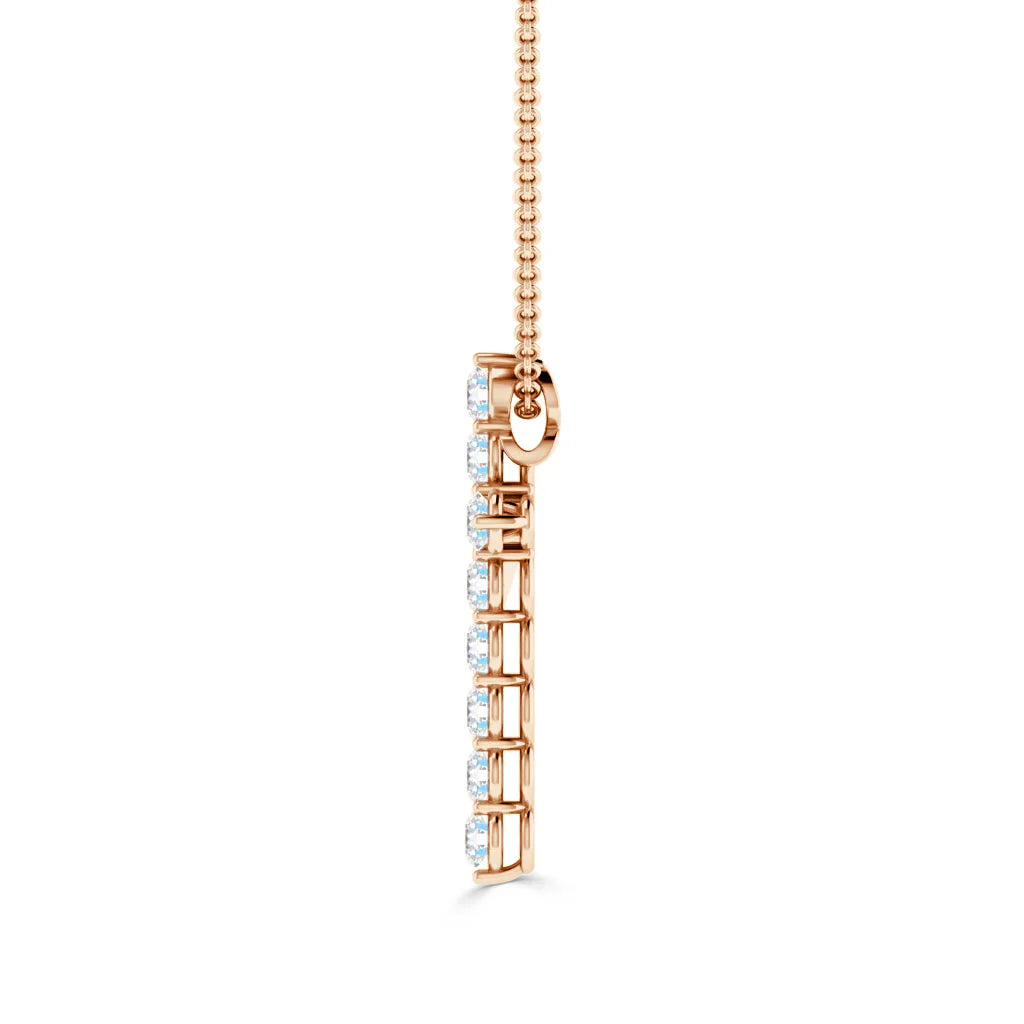 Vertical rose gold necklace pendant with a row of seven diamonds, on a delicate chain, isolated on white.
