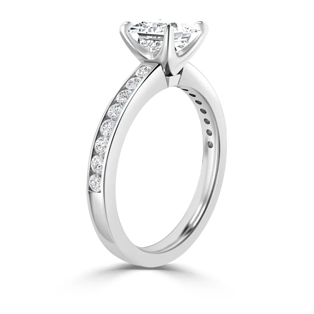 Side view of a white gold ring with a round center diamond and smaller diamonds set along the band.