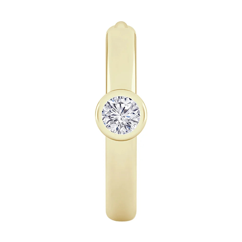 Gold band ring with a single round bezel-set diamond in the center, shown on a white background.