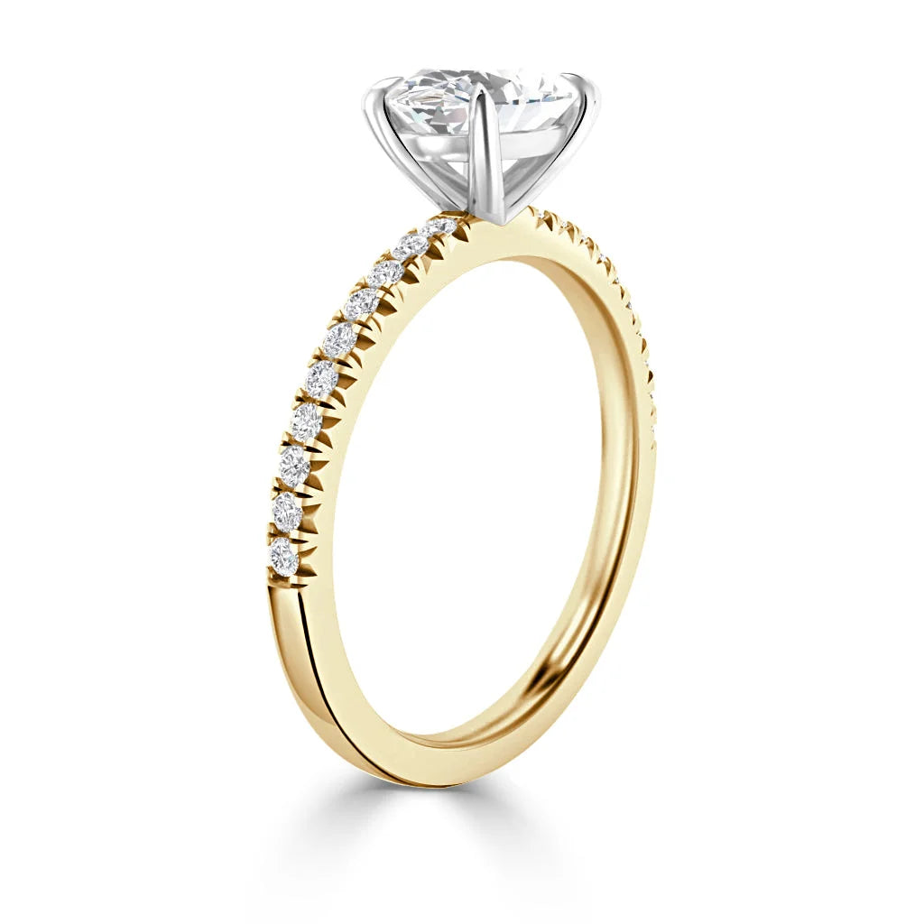 Gold ring with pavé diamonds on the band and a large round solitaire diamond in a white gold prong setting.
