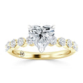 Gold ring with a heart-shaped diamond center and round diamonds set along the band.