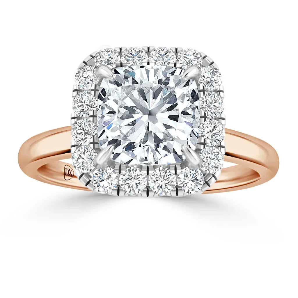 A cushion-cut diamond ring with a halo of smaller diamonds and a rose gold band on a white background.