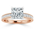 Rose gold ring with a large princess-cut diamond center and channel-set diamonds along the band.