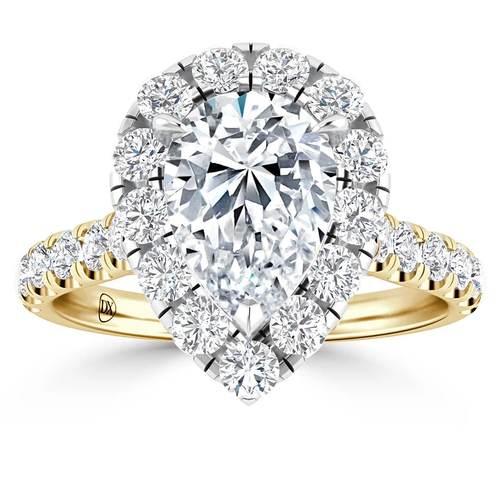 A pear-shaped diamond ring with a gold band, surrounded by a halo and band of round white diamonds.