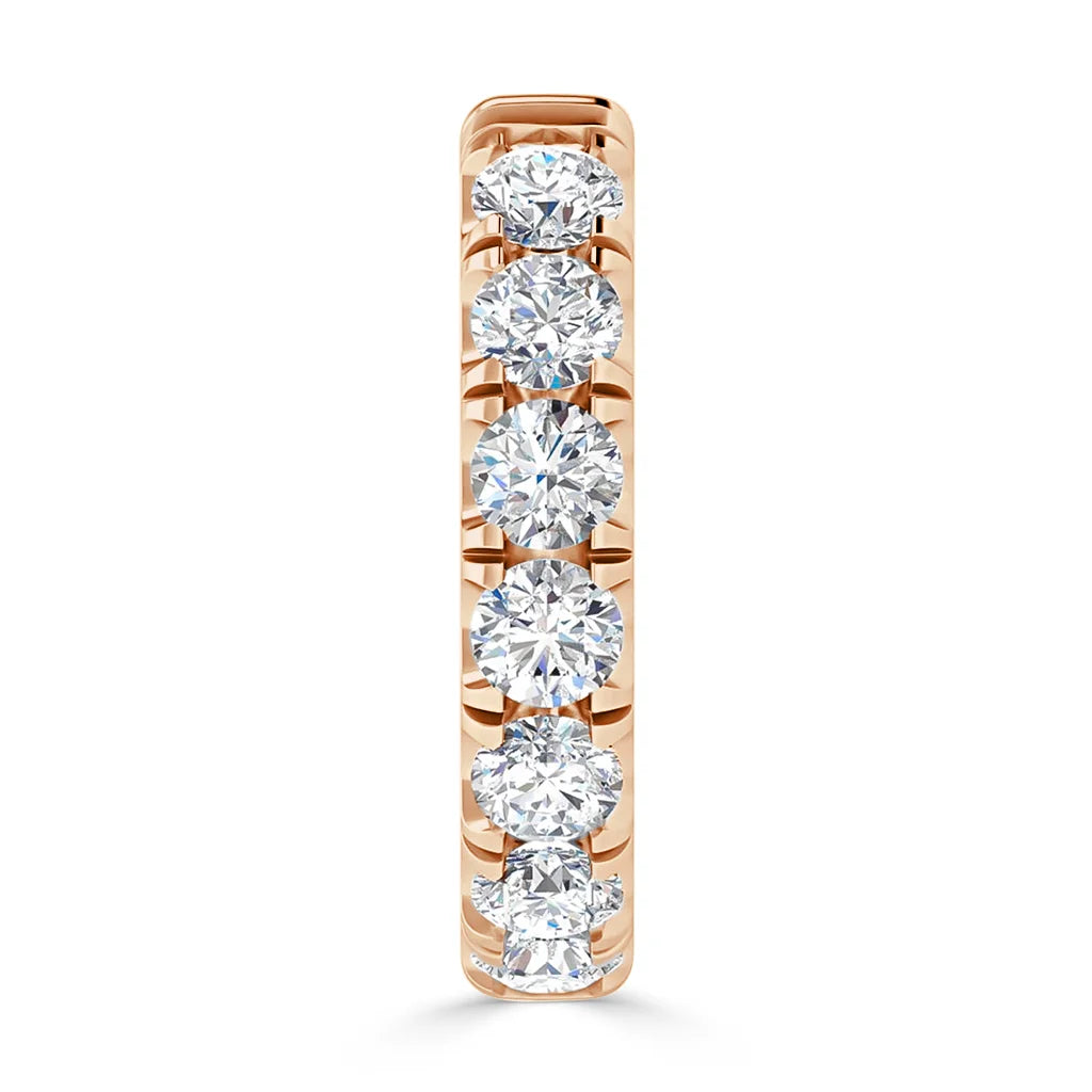 A rose gold ring set with seven round, sparkling diamonds in a vertical row.