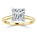 A gold ring with a large, square-cut diamond in a four-prong setting on a plain band.