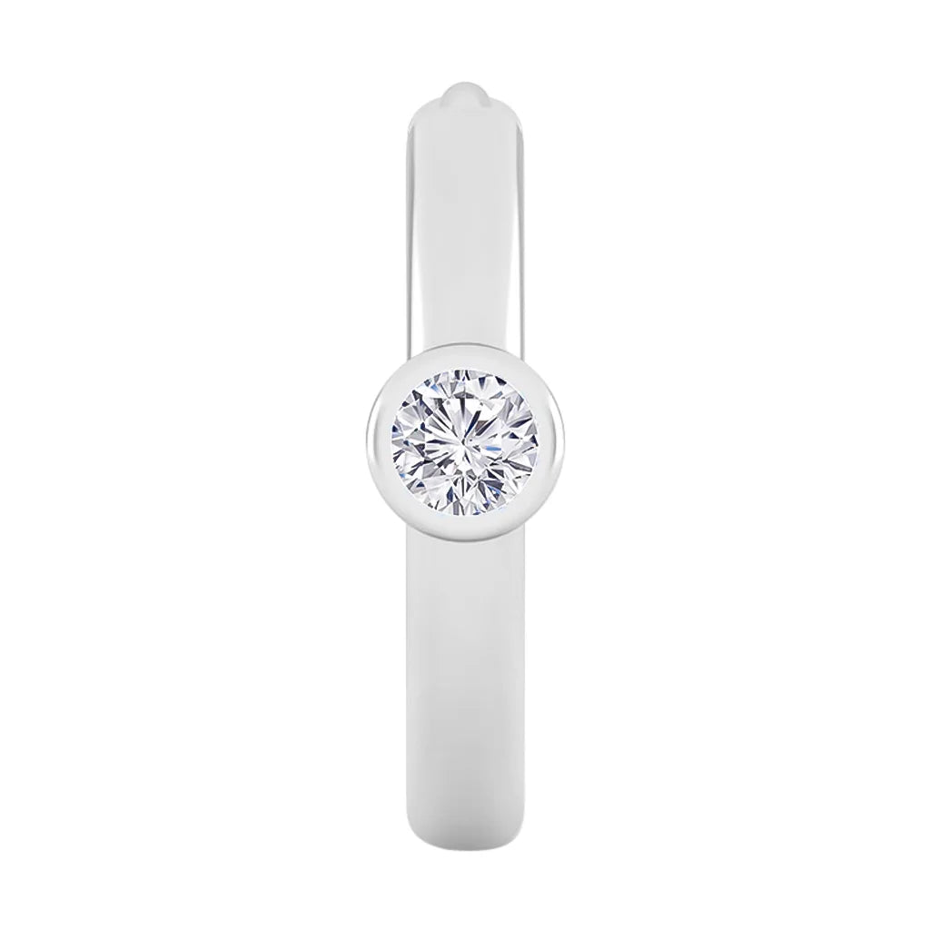 A silver ring with a single round diamond set in a smooth, bezel-style setting on a plain band.