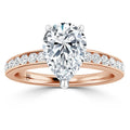 Pear-shaped diamond ring with rose gold band, accented by small round diamonds along the band.