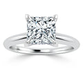 A silver ring with a large, square-cut diamond solitaire set in a four-prong setting on a plain band.