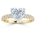 Gold ring with a large heart-shaped diamond center and smaller diamonds along the band.