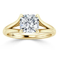 A gold ring with a split shank and a large cushion-cut diamond set in four prongs at the center.
