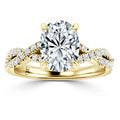 Gold ring with a large oval diamond center stone and a twisted band adorned with smaller diamonds.