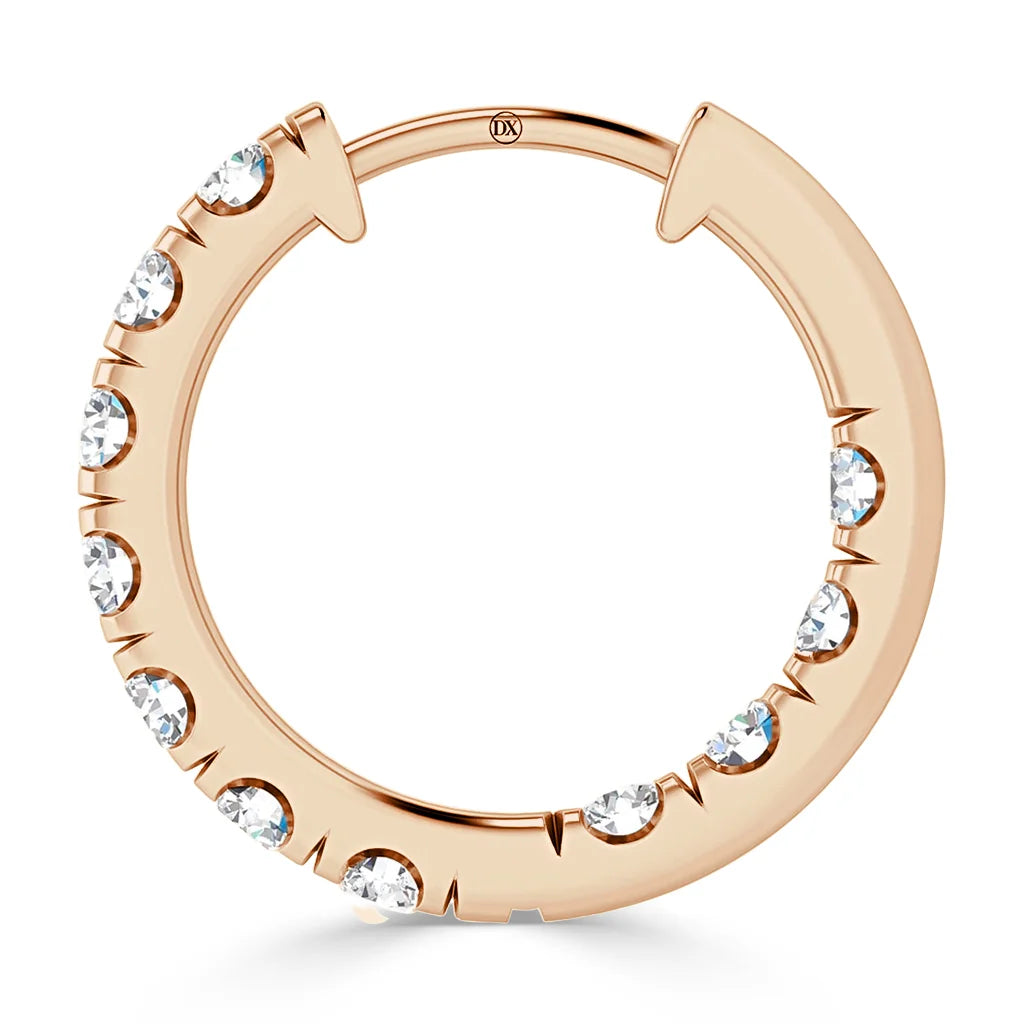 A rose gold hoop earring adorned with evenly spaced round white gemstones along one side.