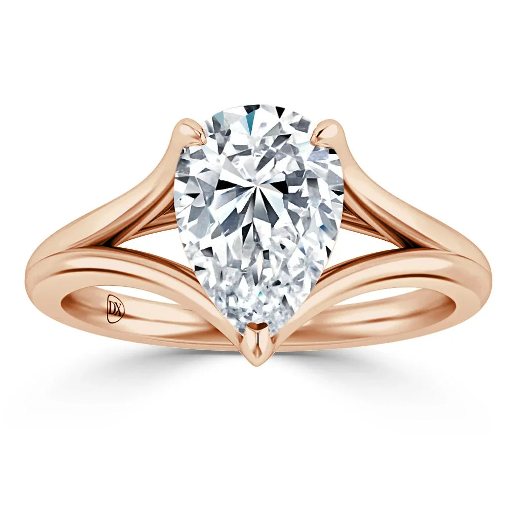 Pear-shaped diamond solitaire ring with a split rose gold band on a white background.