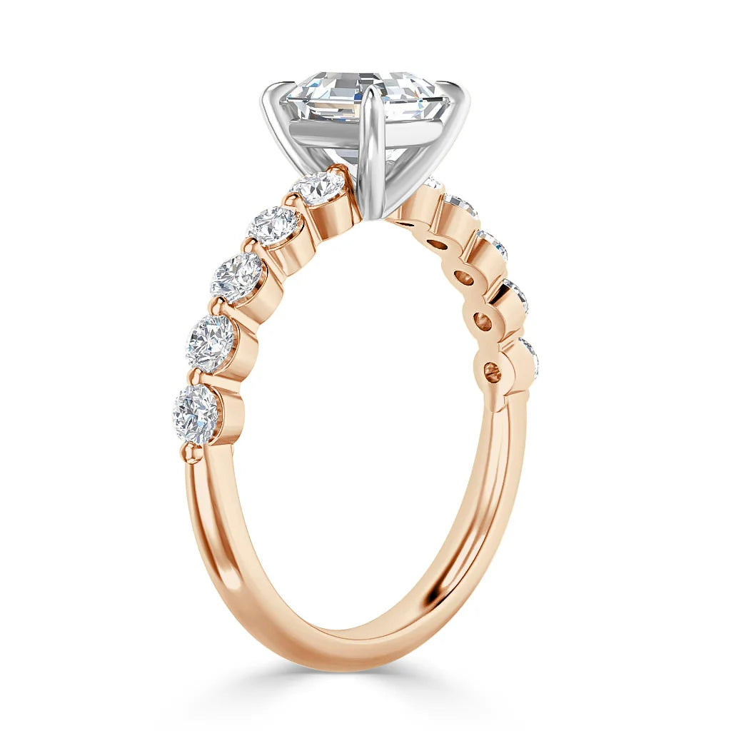 Rose gold ring with side diamonds and a large round solitaire diamond set in a white gold prong setting.