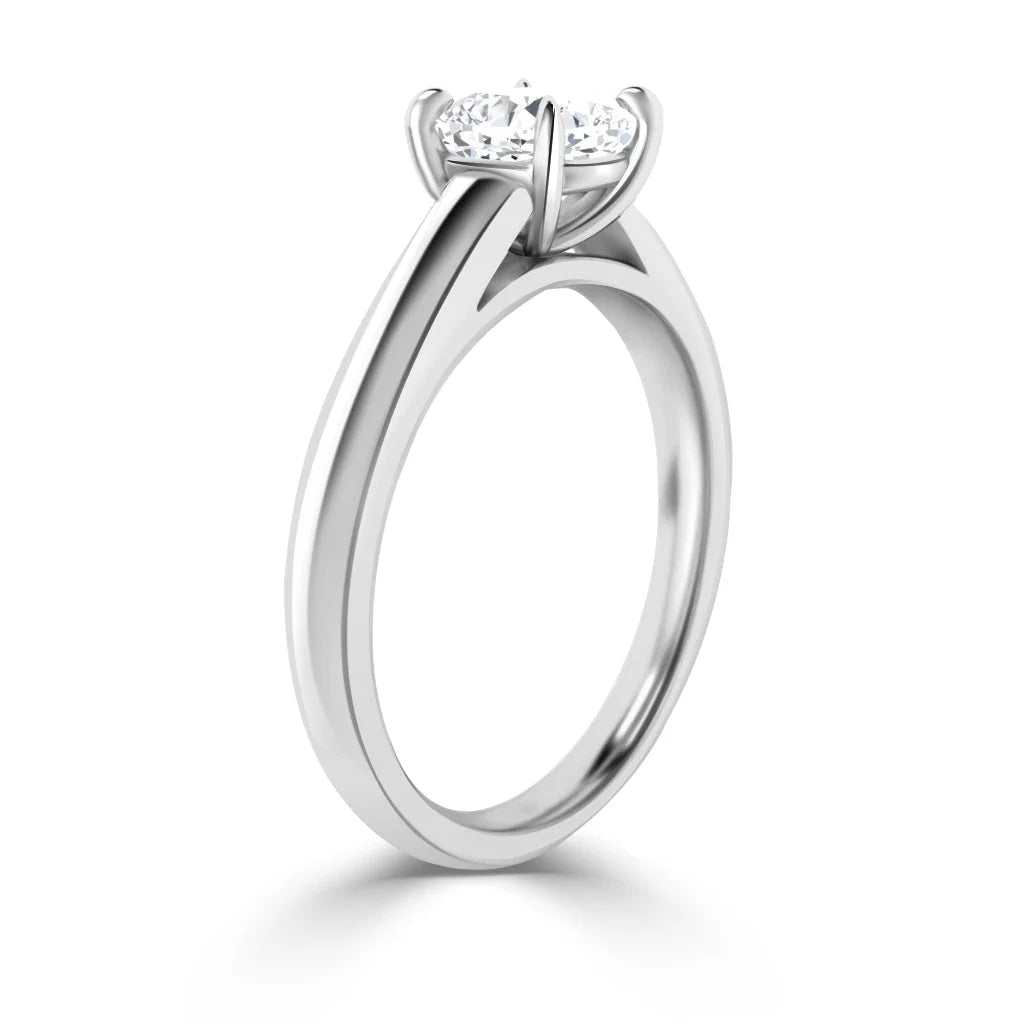 A solitaire engagement ring with a round diamond set in a four-prong white gold band, viewed from the side.