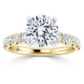 Gold ring with a large round diamond center stone and smaller diamonds set along the band.