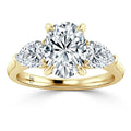 Gold band ring with three round diamonds: one large center stone and two smaller side stones.