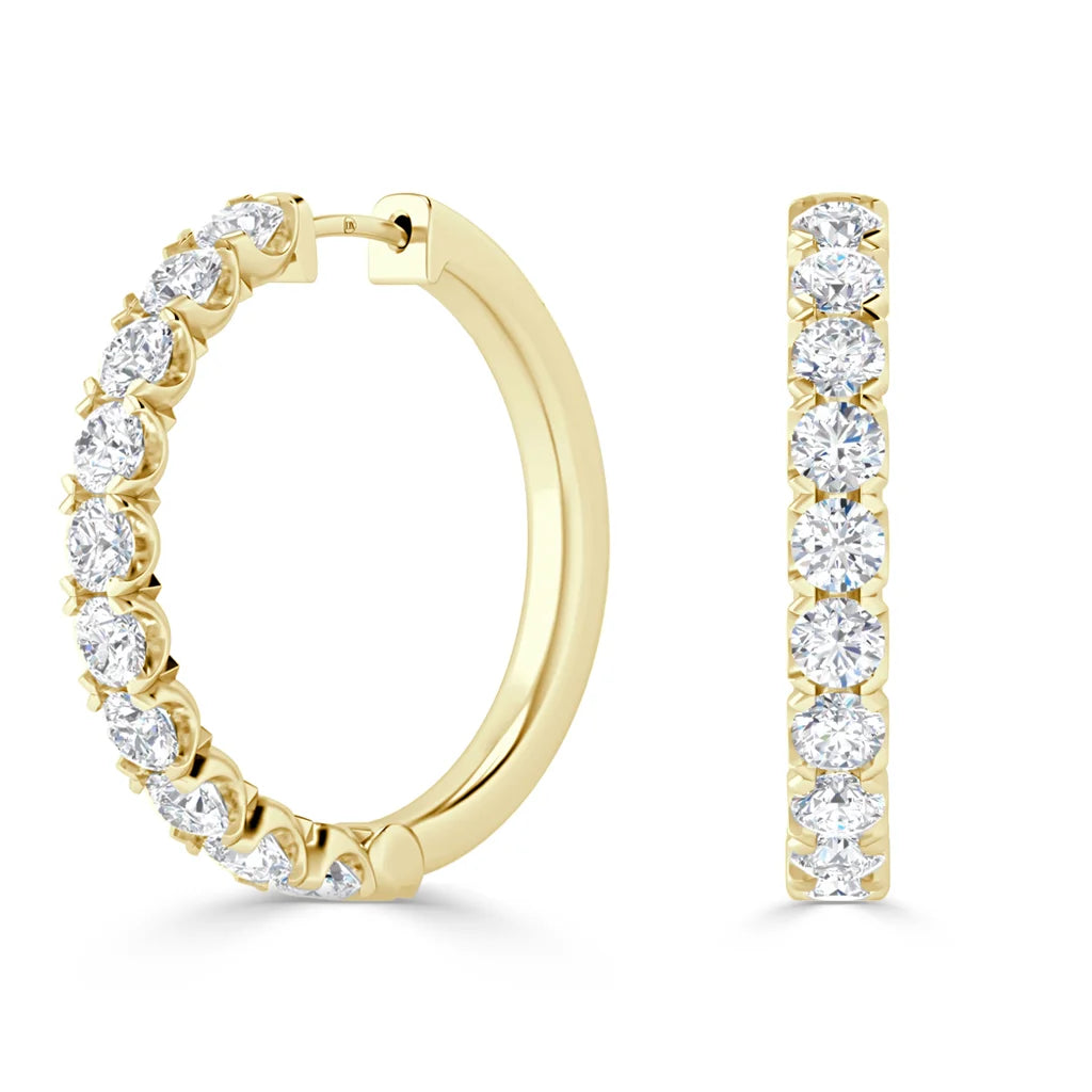 Gold hoop earrings with a row of round, white diamonds set along the front outer edge.
