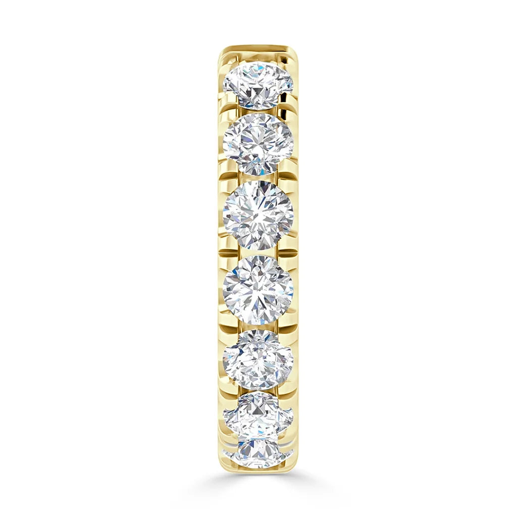A gold ring set with seven round, sparkling diamonds in a vertical row on the band.