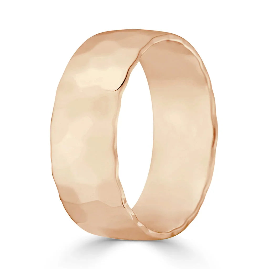 A rose gold ring with a wide, hammered texture and a slightly irregular, organic-shaped band.