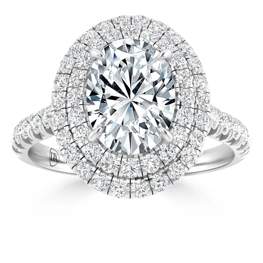 Silver ring with an oval-cut diamond center, double halo of smaller diamonds, and a diamond-encrusted band.