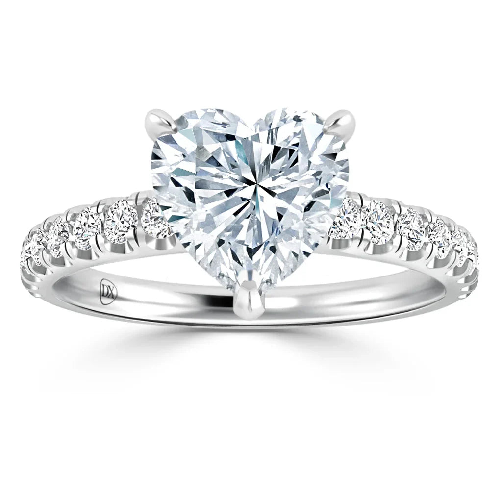 A heart-shaped diamond ring with a band featuring small round diamonds set in white metal.