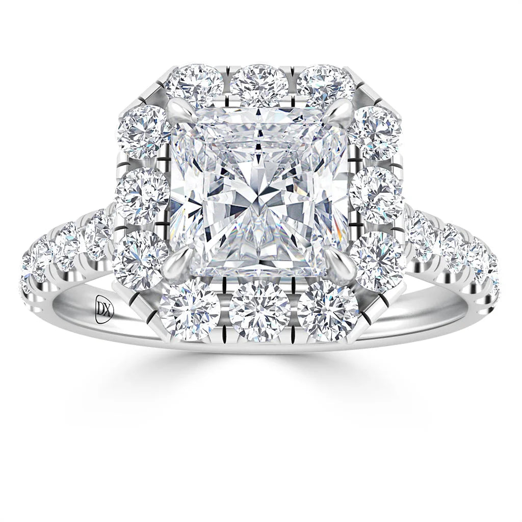 A square-cut diamond ring with a halo and band encrusted with round diamonds set in white metal.
