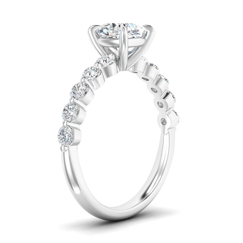 Side view of a white gold ring with round diamonds set along the band and a large center solitaire diamond.
