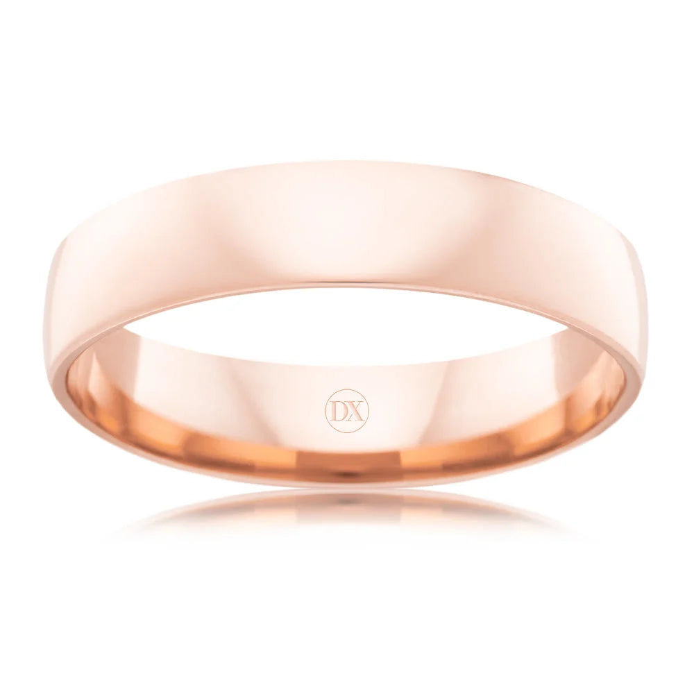 A plain, polished rose gold wedding band with a smooth surface and a “DX” engraving inside.