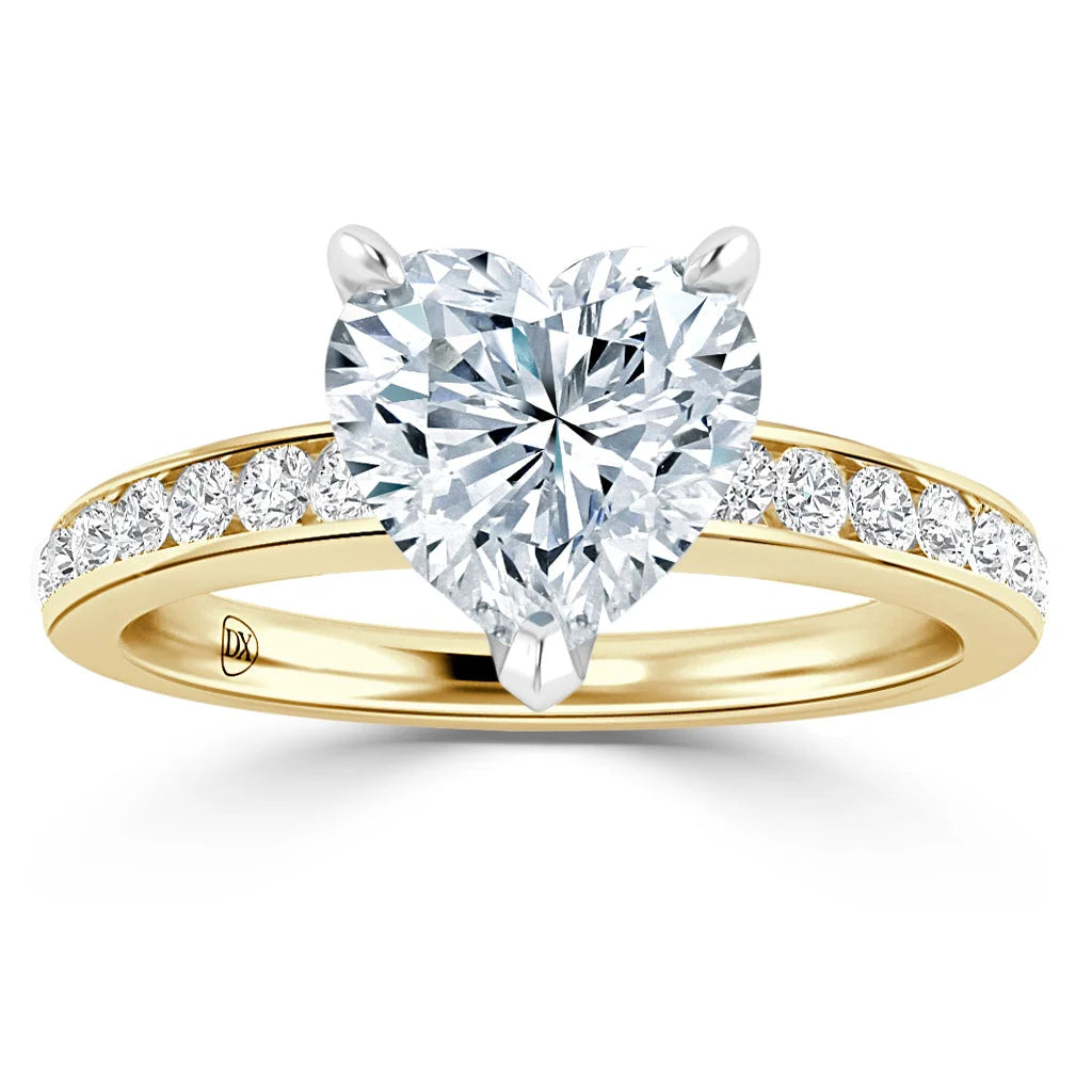 A gold ring with a heart-shaped diamond center stone and smaller diamonds set along the band.